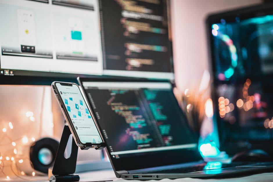 Tehnološki setup s gadgetima, ekranom za programiranje i pametnim telefonom